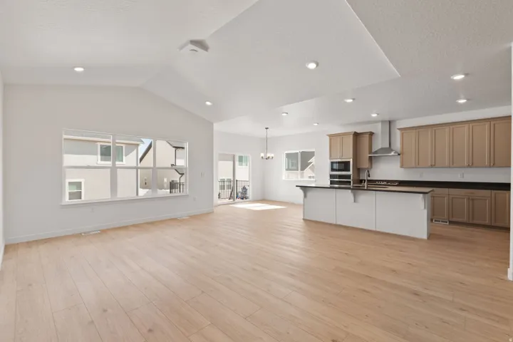 Expansive living area with high vaulted ceilings and wood-finish flooring