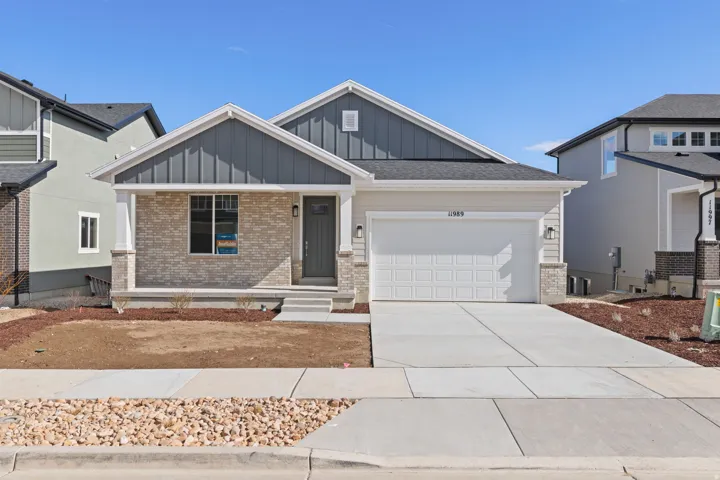 Single-story residence featuring a covered front porch, brick veneer accents, and board and batten siding