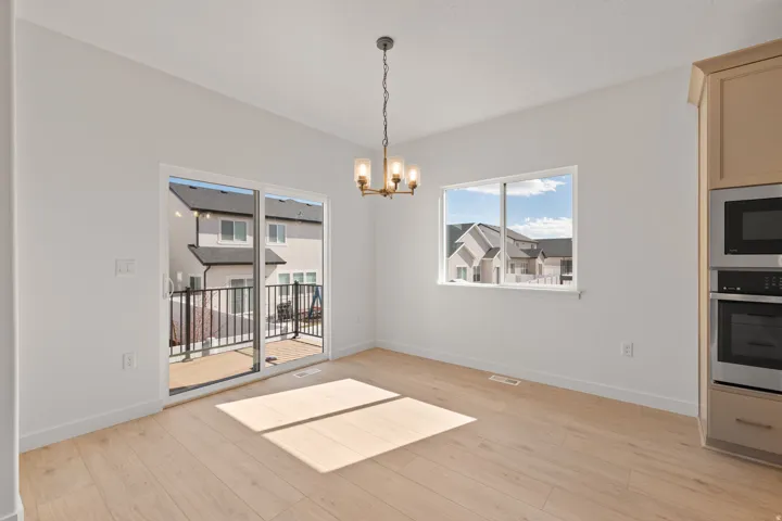 Wood-finish flooring, built-in stainless steel appliances, sliding glass door, and a multi-pane window