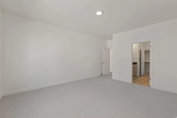 Recessed ceiling lighting, light gray carpeting, neutral wall paint, and white trim