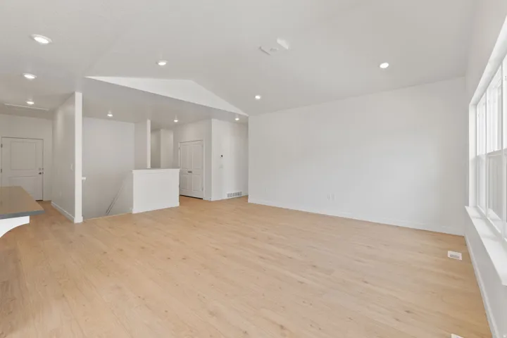 Recessed lighting, wood-finish flooring, white walls, and multi-pane windows