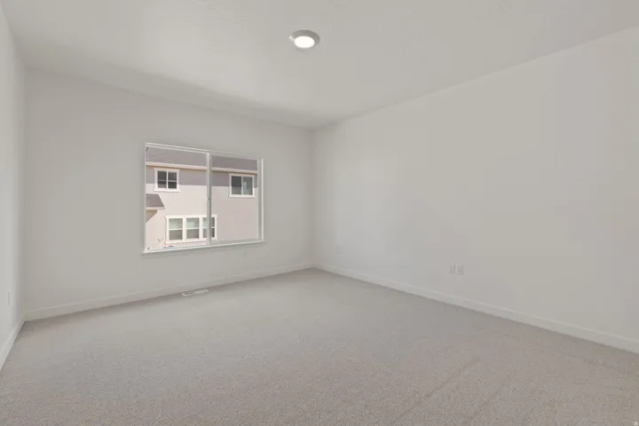 Neutral tone wall paint, recessed ceiling lighting, and light-colored carpeting