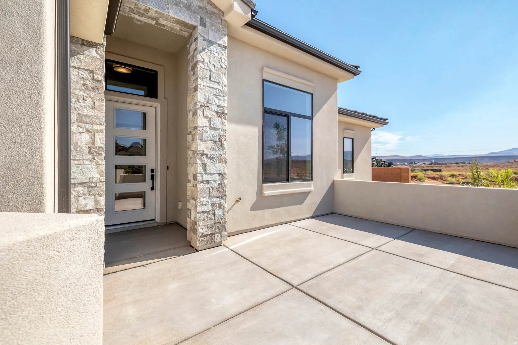 Stucco exterior with stone accents and a covered entryway