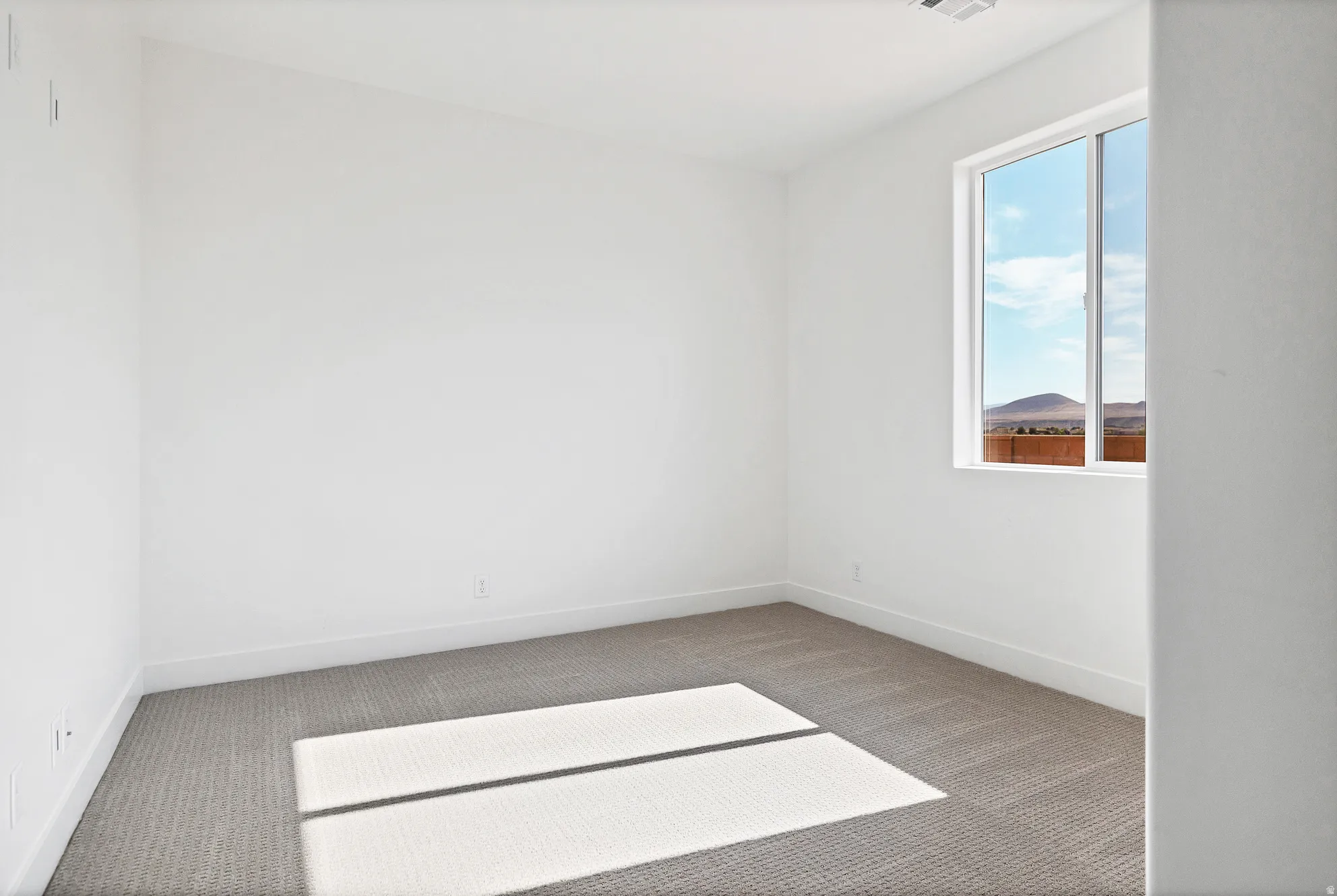 Recessed lighting, white walls, gray carpet flooring, and a large window