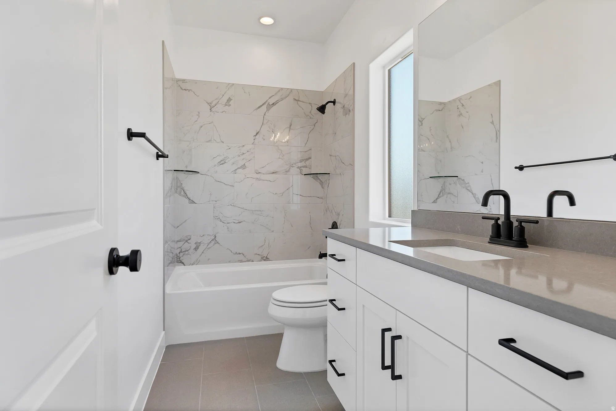 Full bathroom featuring a white vanity with a gray countertop, an integrated sink, and matte black fixtures