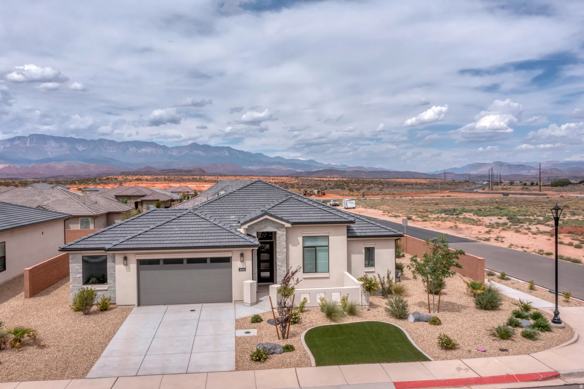 Contemporary home featuring a tile roof, stucco exterior, and an attached two-car garage