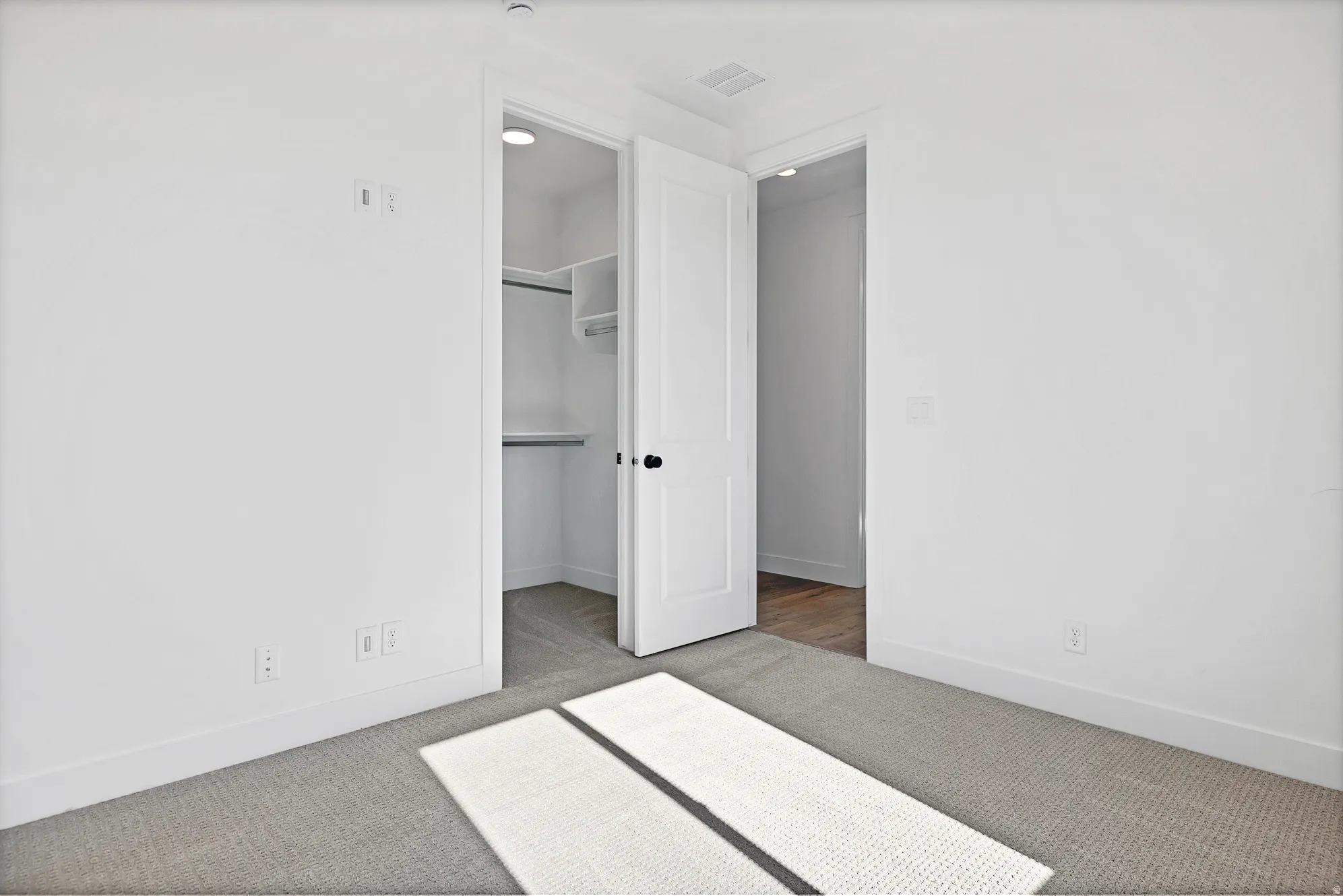 Plush carpet flooring, crisp white walls, and built-in closet shelving