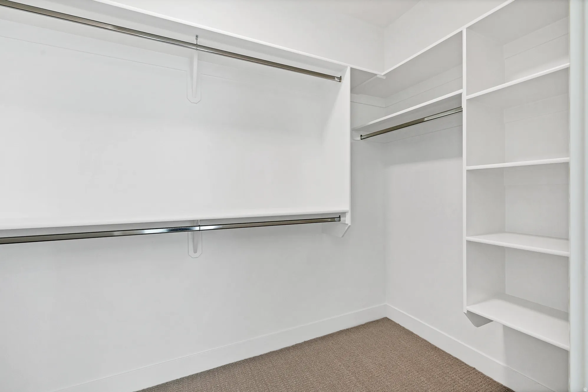 Built-in closet shelving, dual chrome hanging rods, recessed lighting, and carpeted flooring