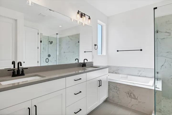 Dual vanity with undermount sinks, stone countertop, and matte black fixtures