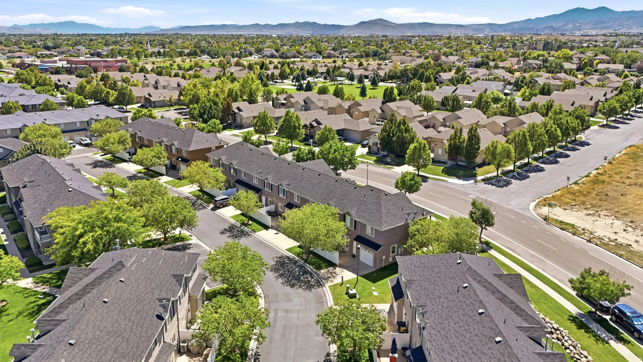 Residential neighborhood with structured streets, established landscaping, and mountain backdrop