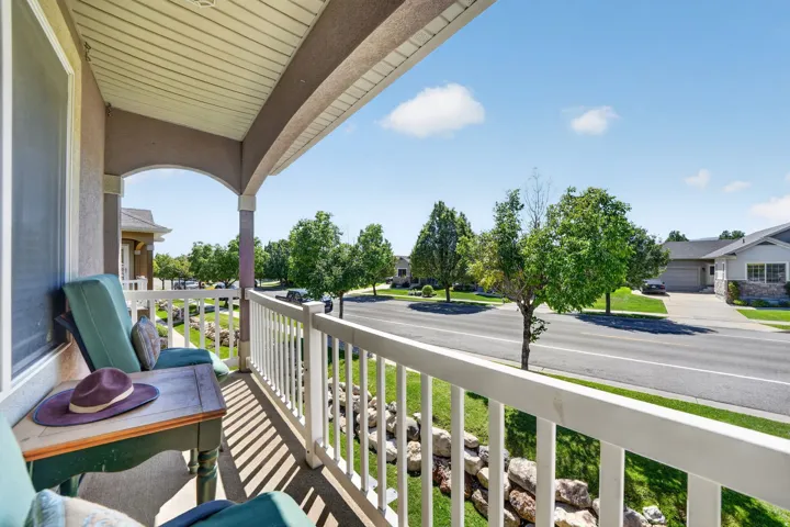 Covered front porch with white railings and an arched entryway