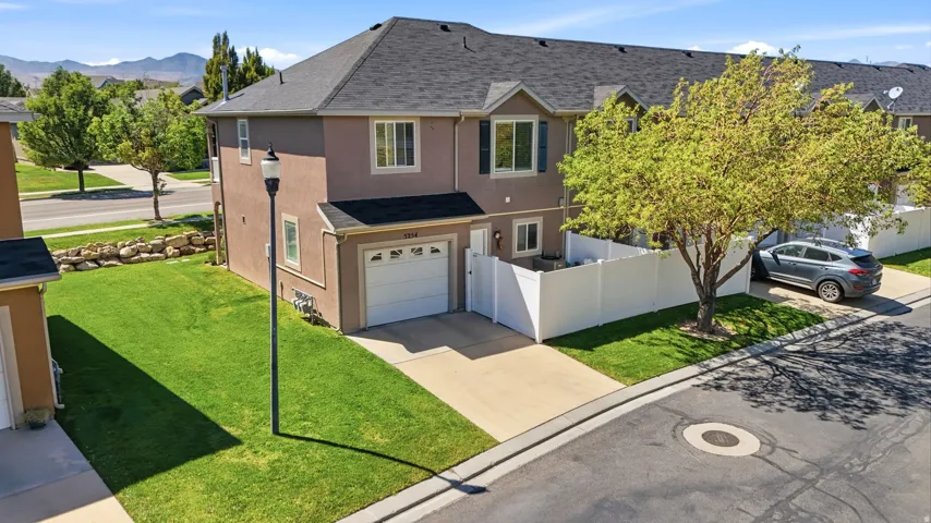 Stucco exterior with a dark shingle roof and white garage door