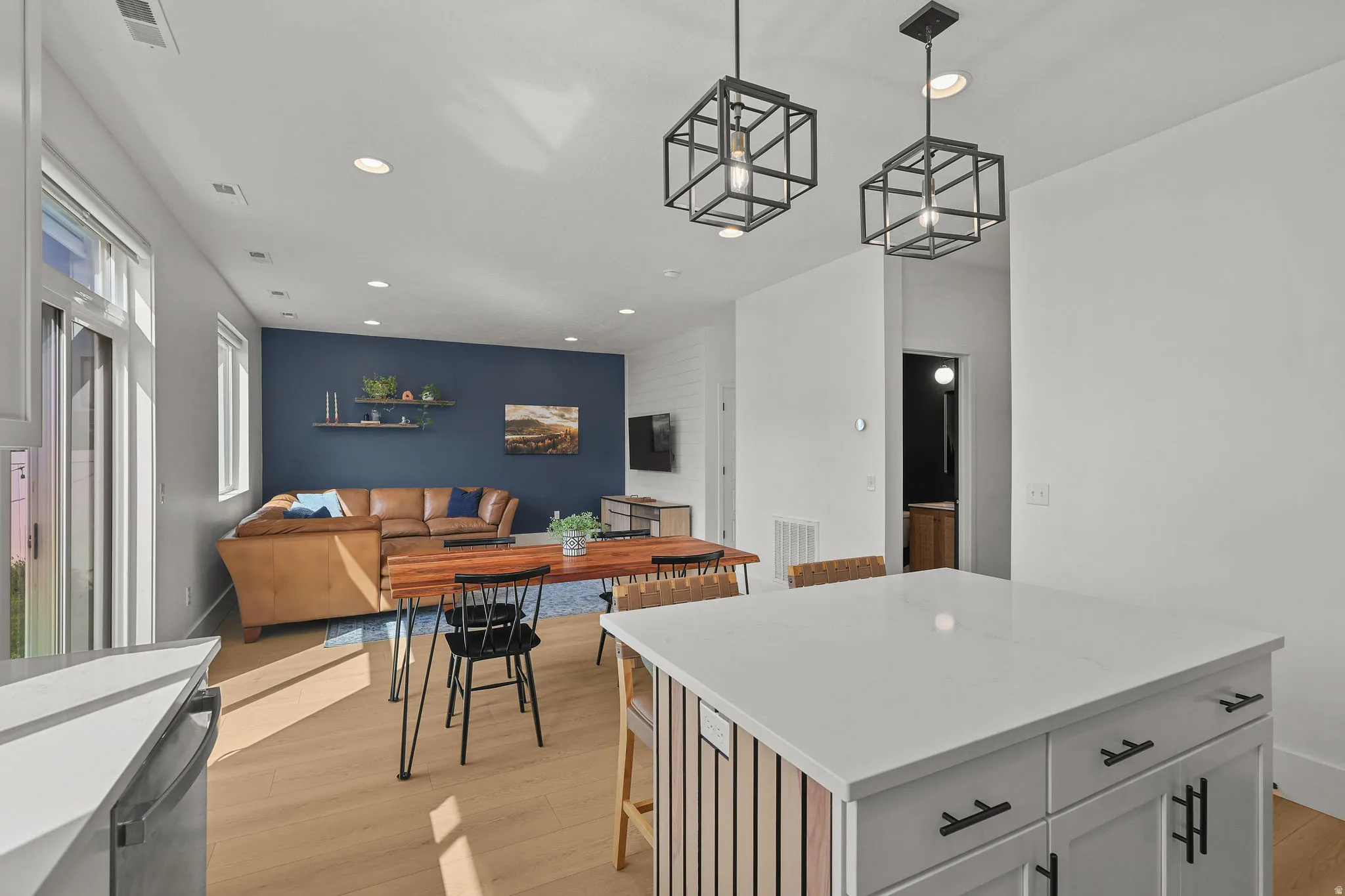Open-concept living space featuring wood-finish flooring, recessed lighting, and a sliding glass door