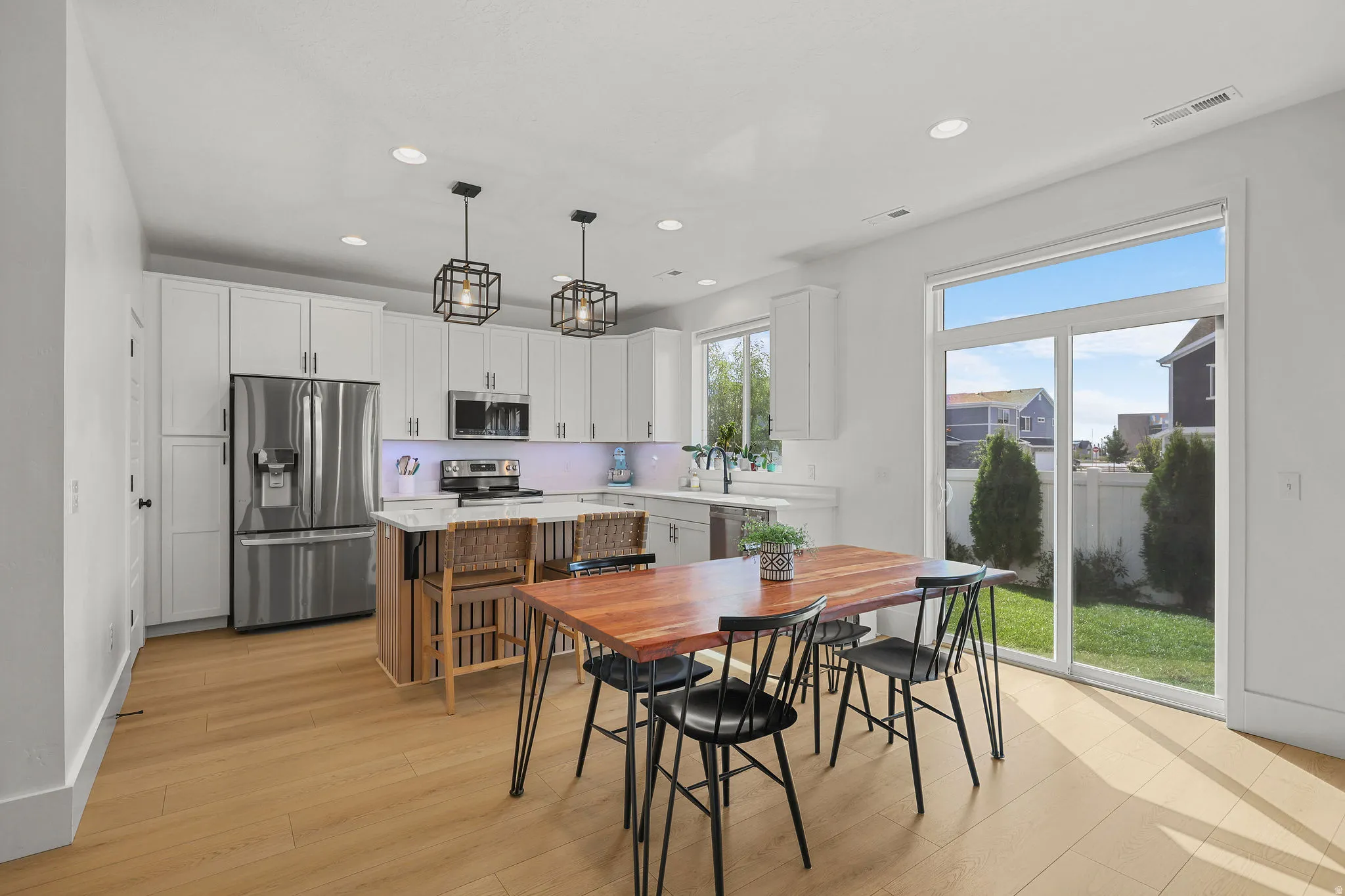 Kitchen featuring white cabinetry, stainless steel appliances, recessed lighting, and wood-finish flooring