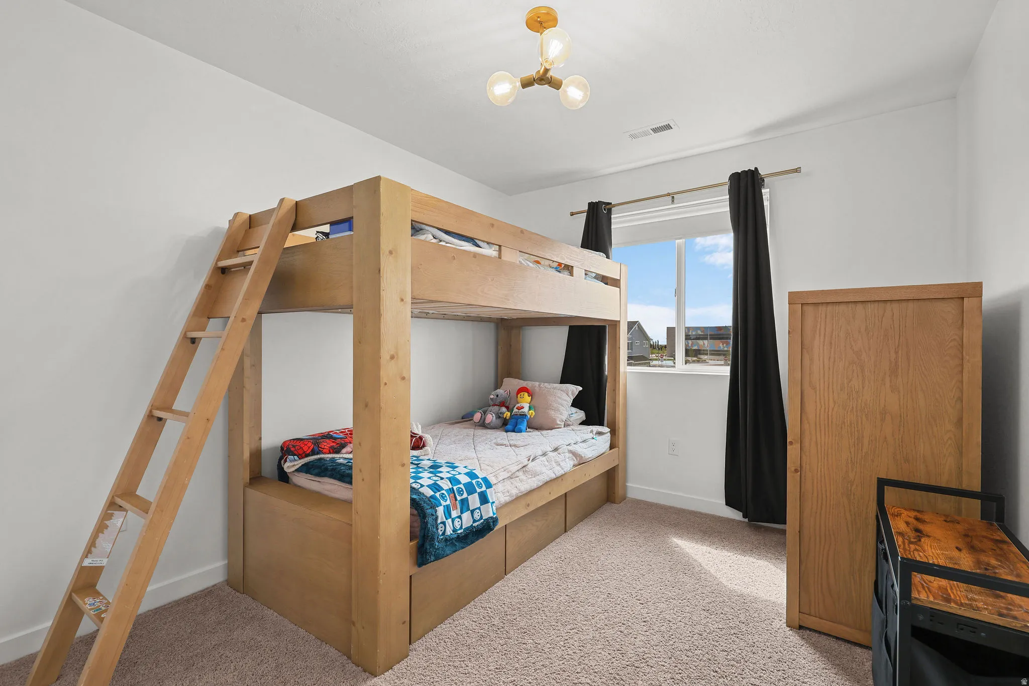 Carpeted flooring, single window with dark curtains, and a ceiling-mounted light fixture