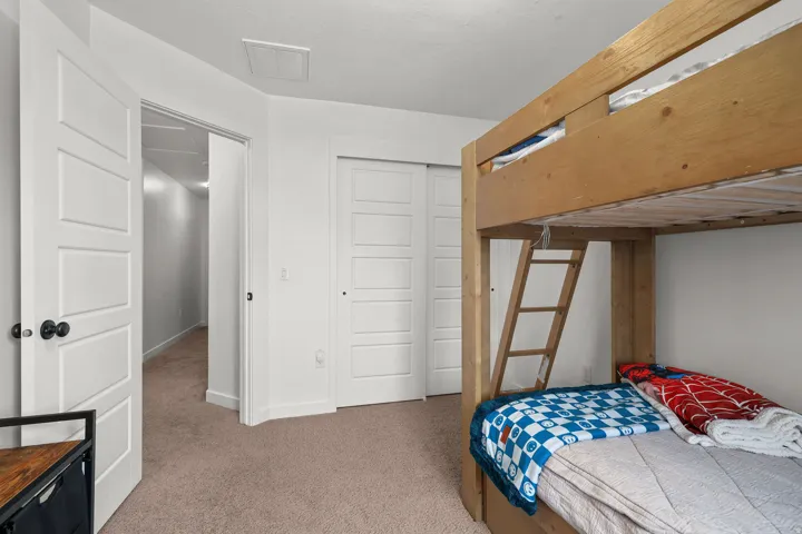 Carpeted flooring, white five-panel interior doors, and sliding closet doors