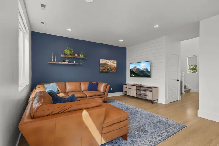 Recessed lighting illuminates the living space featuring wood-finish flooring