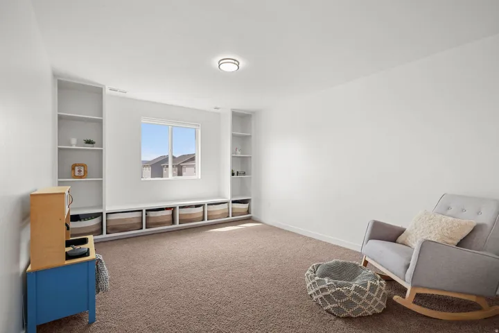 Built-in shelving flanking a window, integrated bench seating, and plush carpet flooring