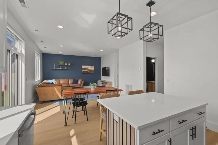 Open-concept living space featuring wood-finish flooring, recessed lighting, and a sliding glass door