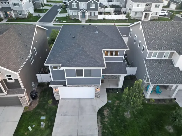 Two-story exterior with dark gray siding and stone accents