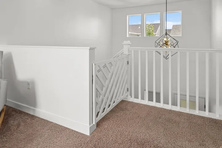 Upper-level landing with white painted railing and a contemporary geometric chandelier