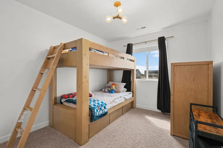 Carpeted flooring, single window with dark curtains, and a ceiling-mounted light fixture