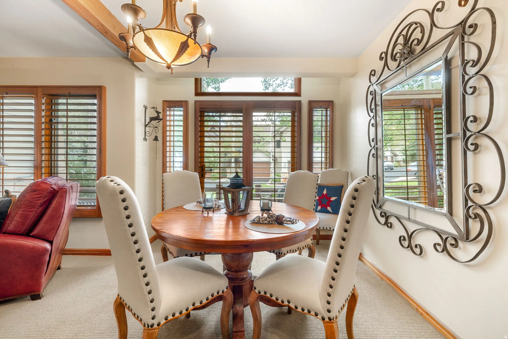 Recessed dining area with a bay window, wood-finish plantation shutters, and a decorative ceiling light fixture with a translucent shade