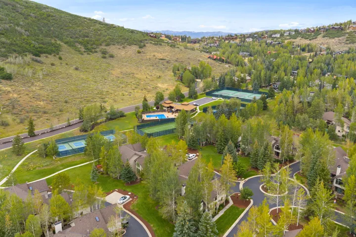 Community setting with multiple tennis courts, a swimming pool, and extensive landscaping