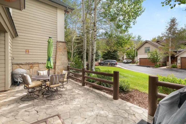 Stamped concrete patio with stone accent wall and wood-style fencing