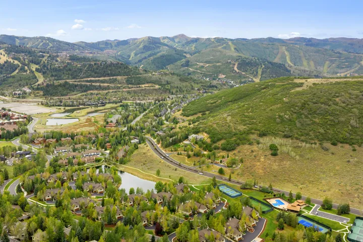 Expansive mountain backdrop, community lakes, lush green landscaping, tennis courts, and a community pool