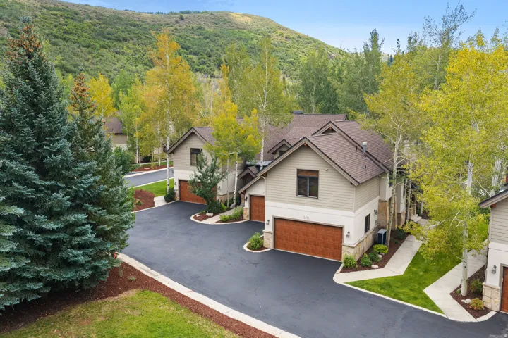 Contemporary exterior with a multi-gabled roofline, stone and siding finishes, and integrated garage doors