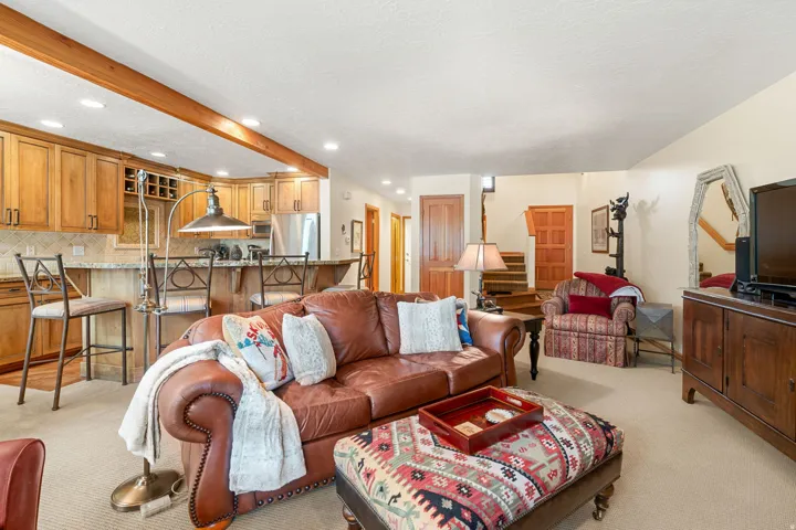 Open concept living area featuring natural wood cabinetry, stainless steel appliances, a breakfast bar with seating, and recessed lighting