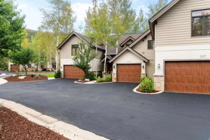 Contemporary-style residential structures featuring light-toned siding and stone accents