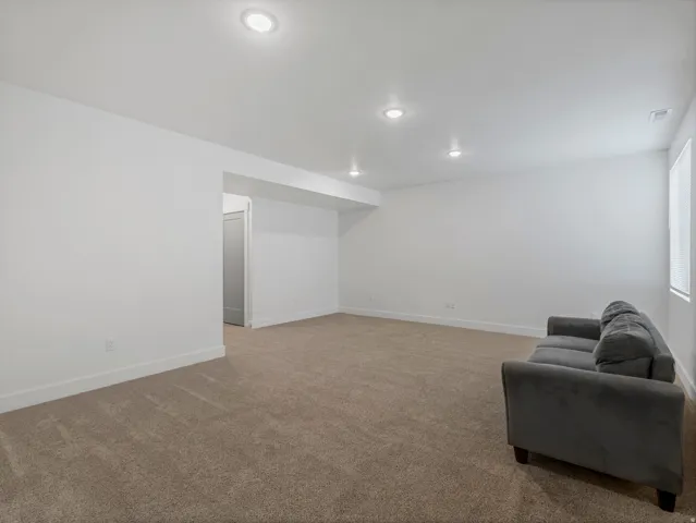 Recessed lighting, neutral tone carpet, white painted walls, and white trim