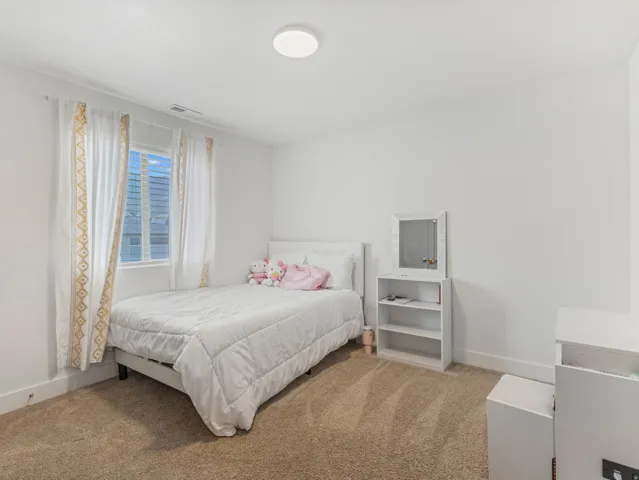 White walls, neutral carpet, and a flush-mount ceiling light fixture