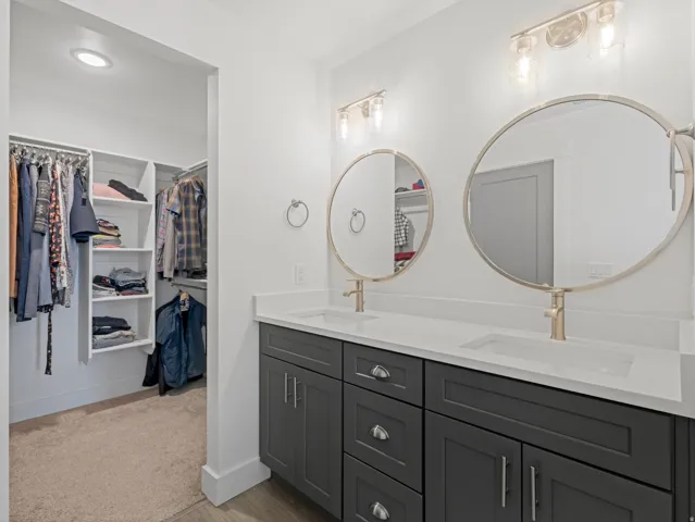 Dual vanity with dark grey cabinetry and white countertops