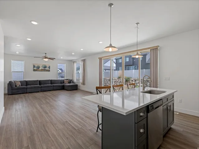 Open-concept living area with wood-finish flooring, recessed lighting, and a ceiling fan