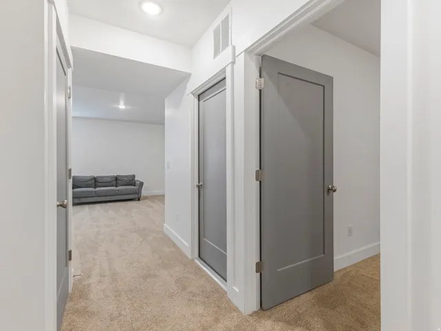 Hallway with recessed lighting, neutral carpet, and white walls