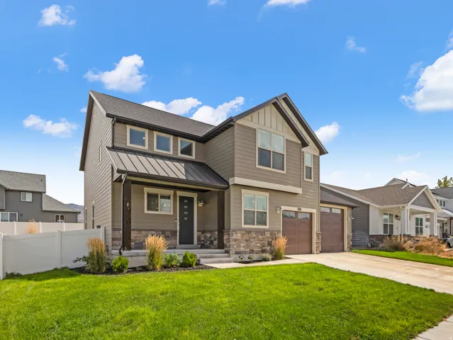 Contemporary exterior with mixed material siding, stone accents, and a metal roof over the entry