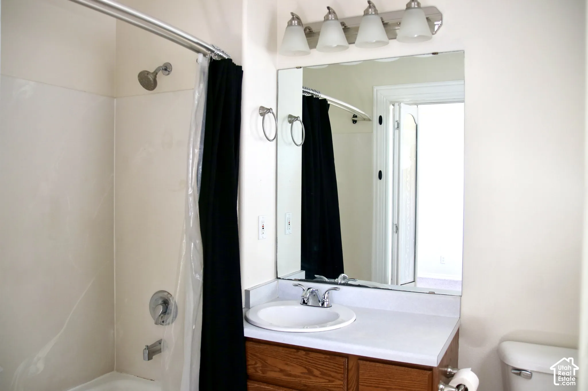 Primary Bathroom featuring a vanity with a wood-finish base, white countertop, and integrated sink