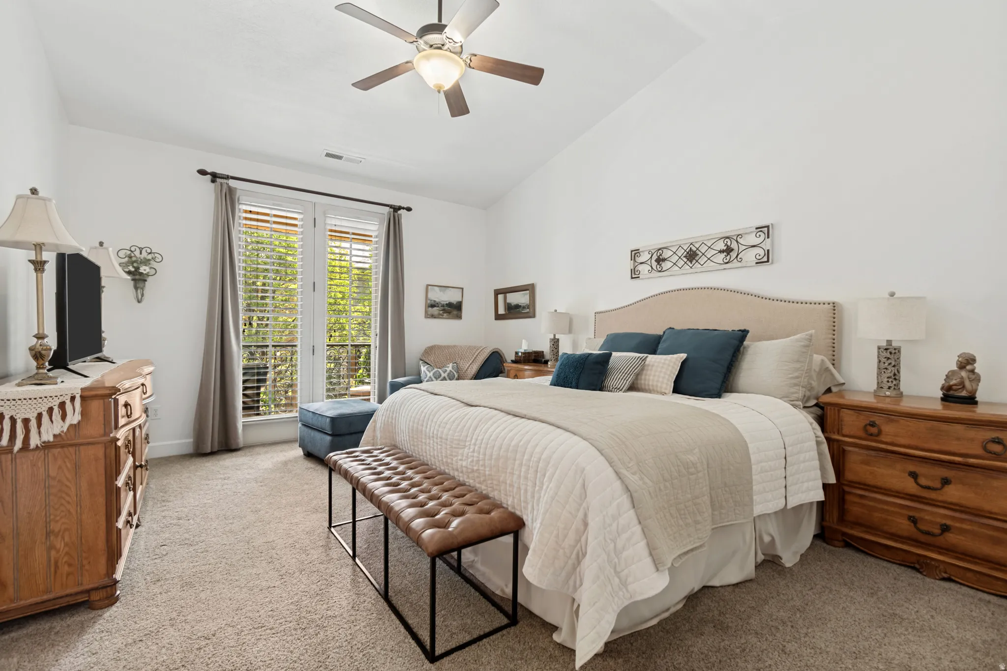 Vaulted ceiling with a ceiling fan, carpeted flooring, and double glass doors with blinds