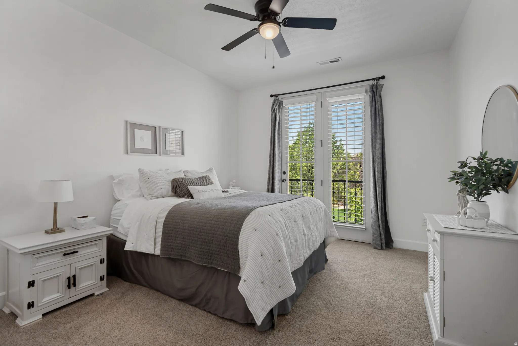 Carpeted room with a ceiling fan, French doors with blinds, and white walls