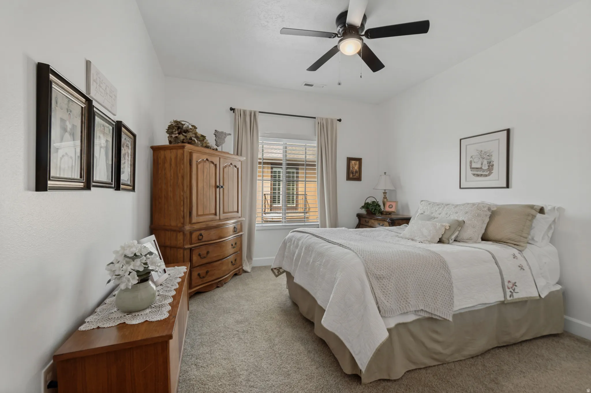 Ceiling fan, window with blinds and drapes, and neutral carpet flooring