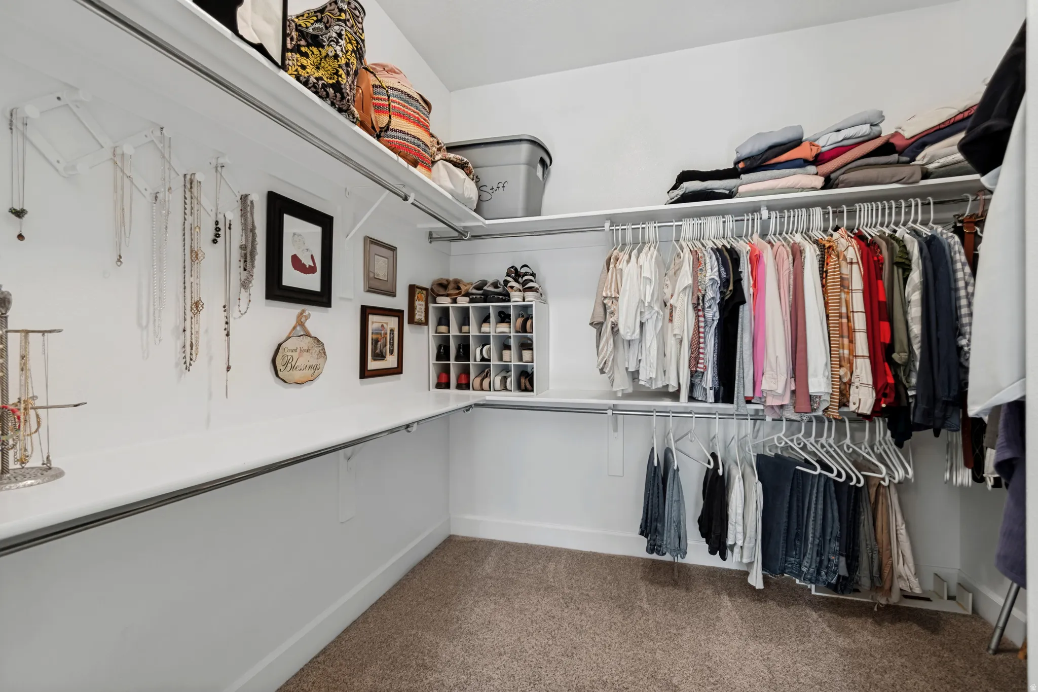 Custom closet system with multiple shelving units and ample hanging space