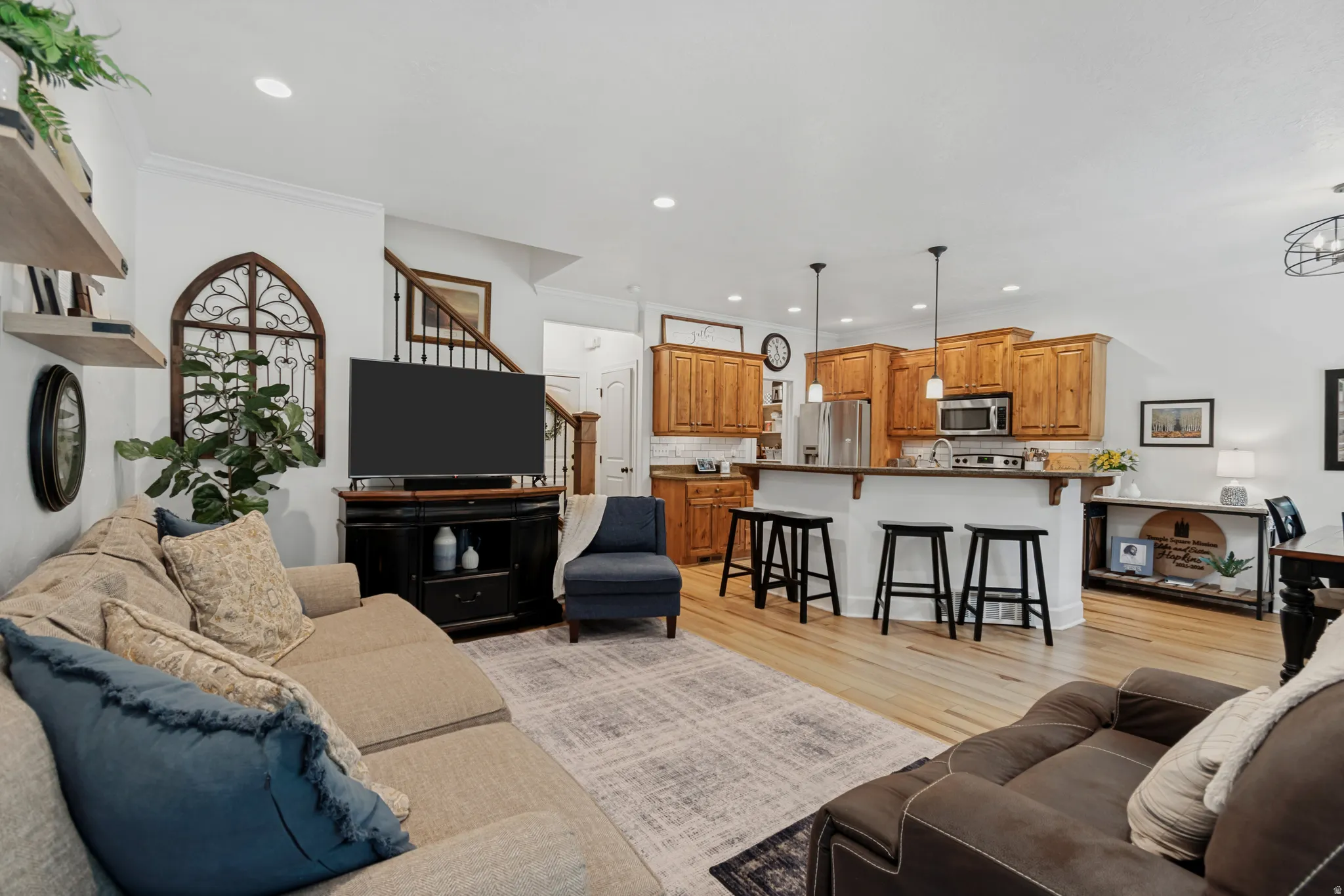 LVP flooring throughout, recessed lighting, wood cabinetry, stainless steel appliances, and a kitchen island with pendant lighting