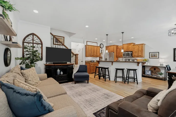 LVP flooring throughout, recessed lighting, wood cabinetry, stainless steel appliances, and a kitchen island with pendant lighting