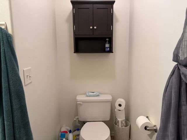 Wall-mounted dark wood-finish cabinet with a shelf