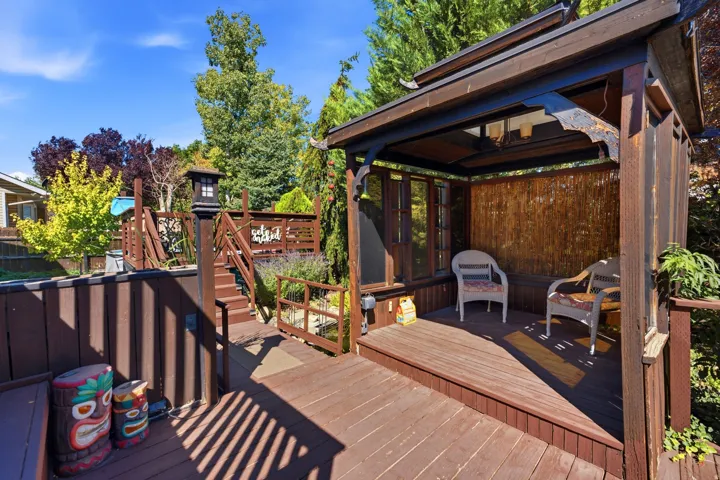 Multi-level wood deck featuring a covered outdoor structure with wood-finish flooring