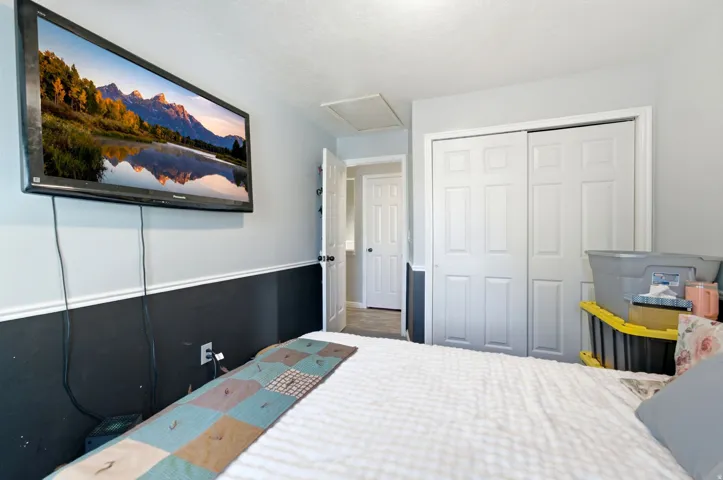 Sliding closet doors, two-tone wall paint, and a built-in wall-mounted television