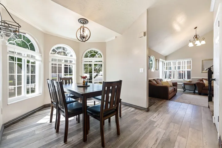 Dining area featuring multiple arched windows, recessed lighting, and wood-finish flooring